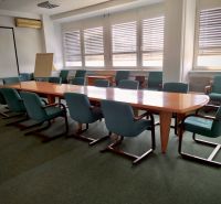 Meeting room with a large table and green chairs in the offices.