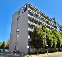 An office building with several floors and trees in Bratislava - Ružinov.