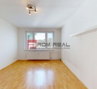 A room with a wooden decor floor, light walls, and a built-in shelf in a 3-room apartment.
