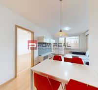 Dining area with a table and red chairs in a 3-room apartment, floor with wood decor.