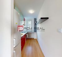 A narrow kitchen in a 3-room apartment with a kitchen unit and a wooden decor floor.