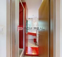 A bathroom in a 3-room apartment with red tiles and a window.