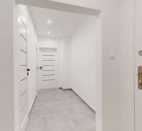 A hallway in a 3-room apartment with white walls and tiled floor.
