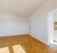 A bright room in a 3-room apartment with a wood-patterned floor and a kitchen nook.