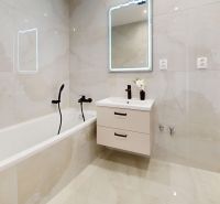 A bathroom with a bathtub, mirror, and cabinet in a 3-room apartment.