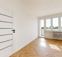 Bright room with wood-patterned flooring and large windows in a 3-room apartment.