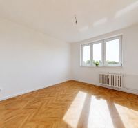 A room with a wooden floor decor and a large window in a 3-room apartment.