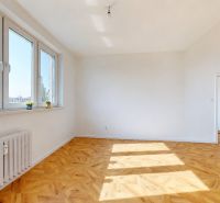 A bright room with large windows and a wooden decor floor in a 3-room apartment.