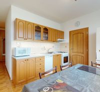 A kitchen in a 3-room apartment with light furnishings and wooden cabinet decor.