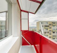 A balcony in a 3-room apartment in Nitra with a view of apartment buildings and a net.
