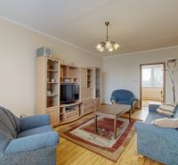 Living room in a 3-room apartment with a wooden decor floor and a blue sofa.