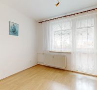 A room in a 3-room apartment with a wooden decor floor and a large window.