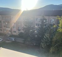 A view of apartment buildings in Rožňava with a view of greenery and mountains.