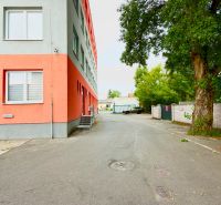 Exterior on Strojnícka Street in Ružinov near warehouses and halls, next to a tree and a building.