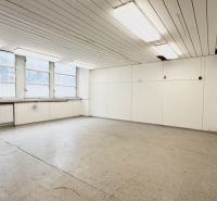 A bright room with four large windows and a sink, suitable for storage and halls.