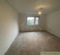 An empty room in a family house with a window and a wooden decor floor.