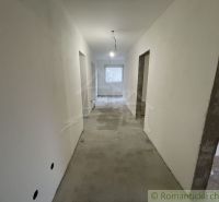 A hallway in a family house with smooth walls and a concrete floor.