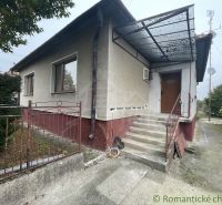 A family house in Šurany with a covered veranda, garden, and rustic fence.