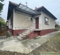 A family house in Šurany with plaster, metal railing, and a metal roof.