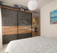 Bedroom with a large wardrobe and a picture of a beach in a holiday apartment.