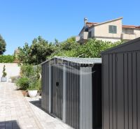 Garden at the holiday apartment in Srima with outdoor storage spaces and greenery.