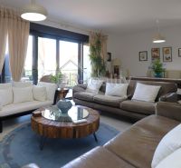 The holiday apartment offers a bright living room with comfortable sofas and wooden decor.