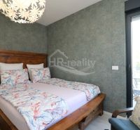 Double bed in a Holiday Apartment, with patterned linen and ceiling light.