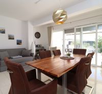 A recreational apartment with a dining table and a spacious living area with large windows.