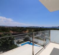 View from the holiday apartment in Tribunj of greenery, pool, and sea.