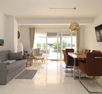 Living room in a holiday apartment with comfortable seating and a dining table.