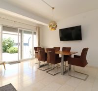 Dining room of a recreational apartment with a television and a large window letting in light.