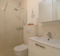 A bathroom in a holiday apartment with a modern shower and sink.