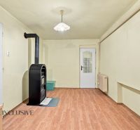 Interior of a family house with a wooden decor floor and a black tiled stove.