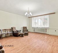 A living room in a family house with armchairs, chairs, and a wooden decor floor.
