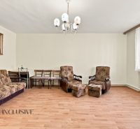 Living room in a family house with a wooden decor floor, complemented by upholstered furniture.