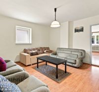 Living room of a family house with a comfortable sofa set and a coffee table on a floor with a wooden decor.