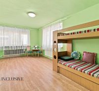 Children's room with a bunk bed, a desk, and a wooden decor floor in a family house.