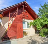 A family house in Veľký Meder with a light facade and red wooden elements.