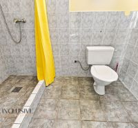 Bathroom with a toilet, shower, and yellow curtain in a family house.