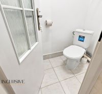 Small bathroom in a family house with a toilet and white walls.