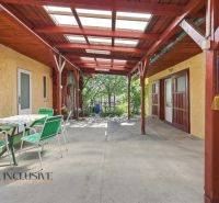 Covered terrace of a family house in Veľký Meder with green chairs and a table.