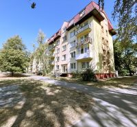 A four-story building with balconies and trees on A. Hlinku Street in Piešťany.