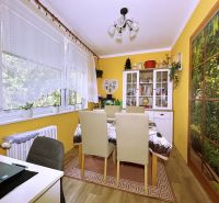 Dining room in a 4-room apartment with yellow walls and wood-patterned flooring.