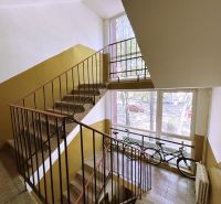 The staircase of an apartment building on A. Hlinka Street in Piešťany, two bicycles by the window.