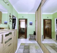 A classic hallway with green walls in a 4-room apartment with a large mirror.