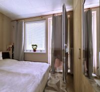 Bedroom in a 4-room apartment with a bed, window, and wardrobe.