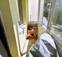Glazed balcony in a 4-room apartment with storage needs and clothes hangers.