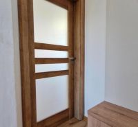 Wooden doors and a floor with a wooden decor in a 3-room apartment.