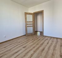 An empty room with a wooden decor floor in a 3-room apartment.