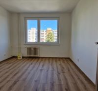 A spacious room with a wooden decor floor in a 3-room apartment.